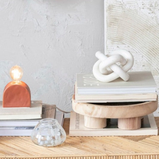 White Marble Triple Chain Link Knot Decor shon atop books sitting on a round wood riser