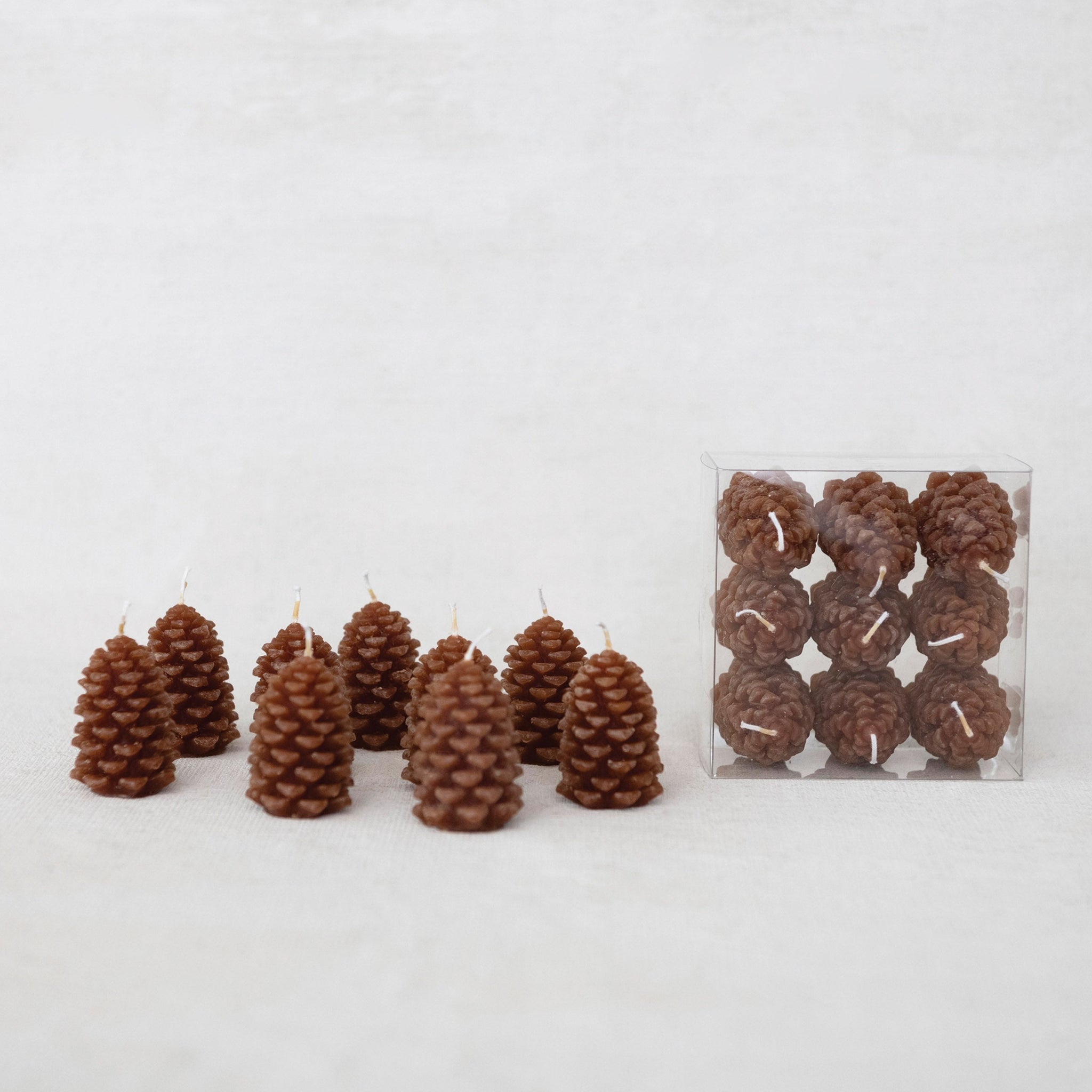 small narrow brown pinecone tealight votive candles come in clear plastic box set of 9