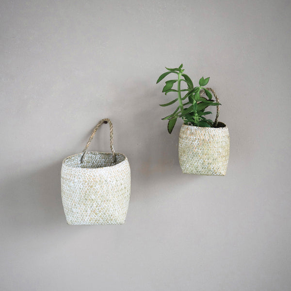 Whitewashed handwoven seagrass wall baskets with handle for hanging.
